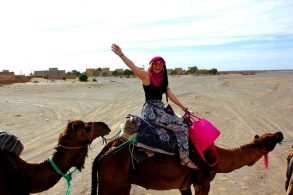 Imagen de una mujer montada en un camello en un desierto