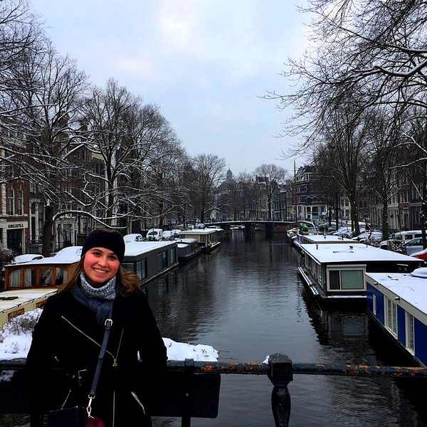 Imagen de una estudiante posando frente a un canal en Amsterdam