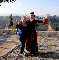 Imagen de estudiante posando con un bailarina frente el Alhambra en España