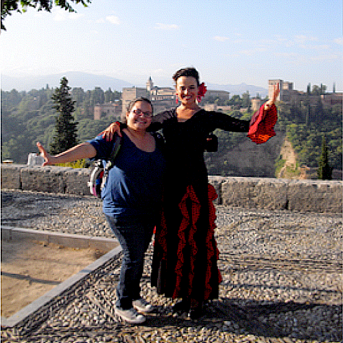Imagen de estudiante posando con un bailarina frente el Alhambra en España